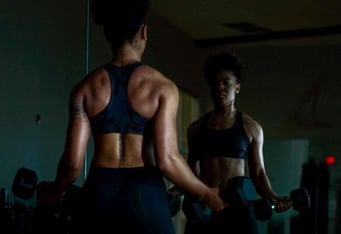 woman facing mirror while doing workout routine