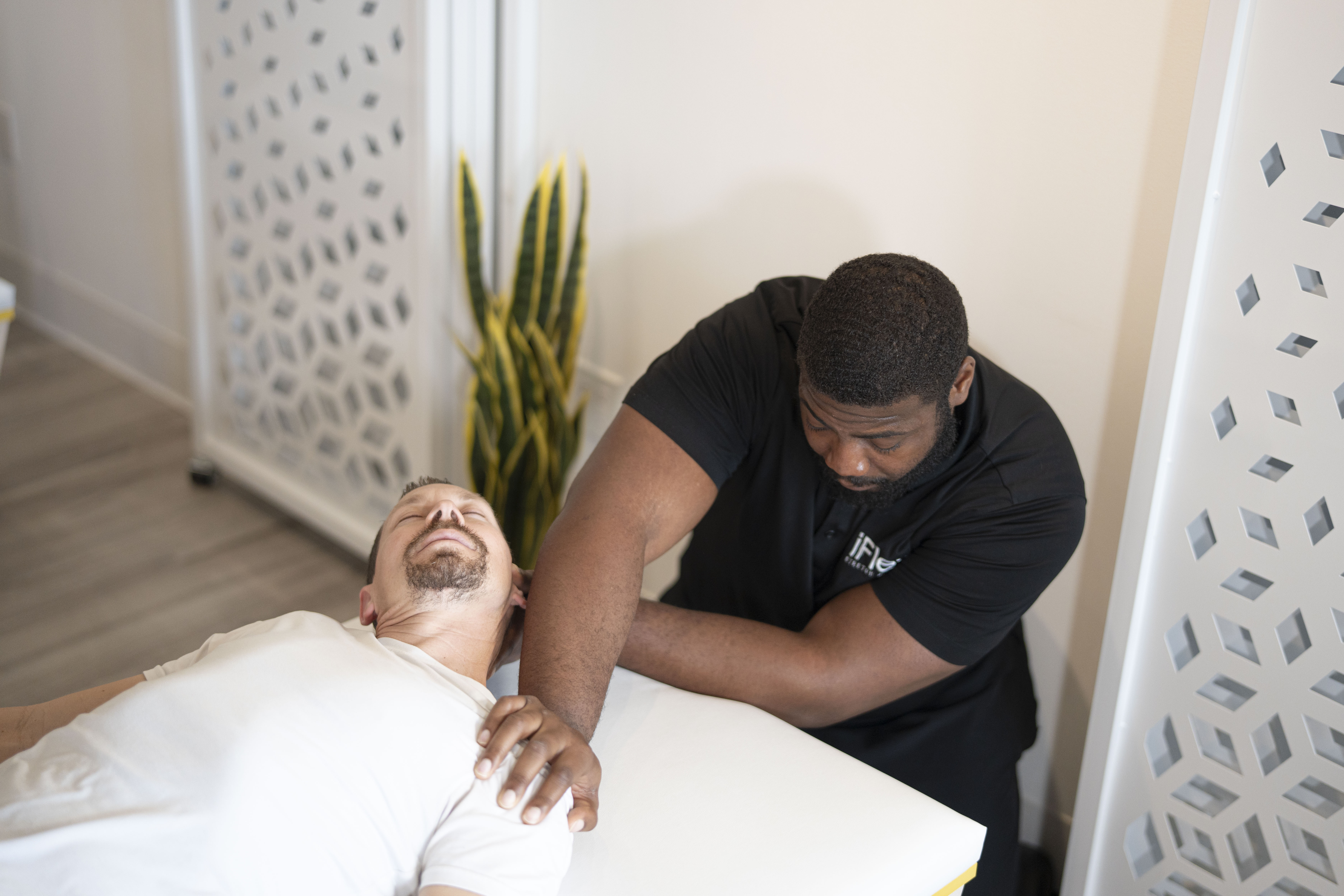 man getting an upper body assisted stretch from an iFlex stretch therapist