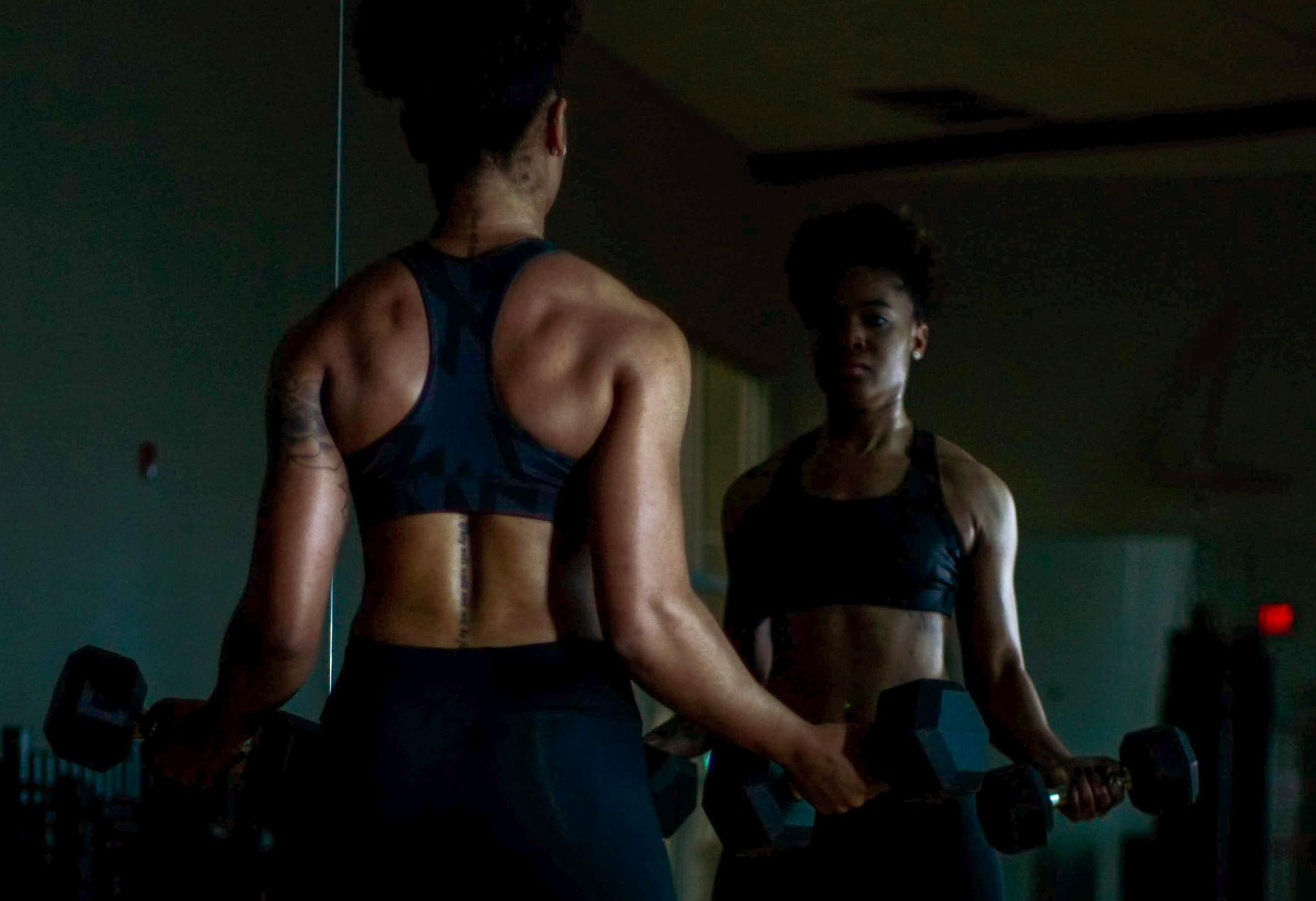 woman facing mirror while doing workout routine